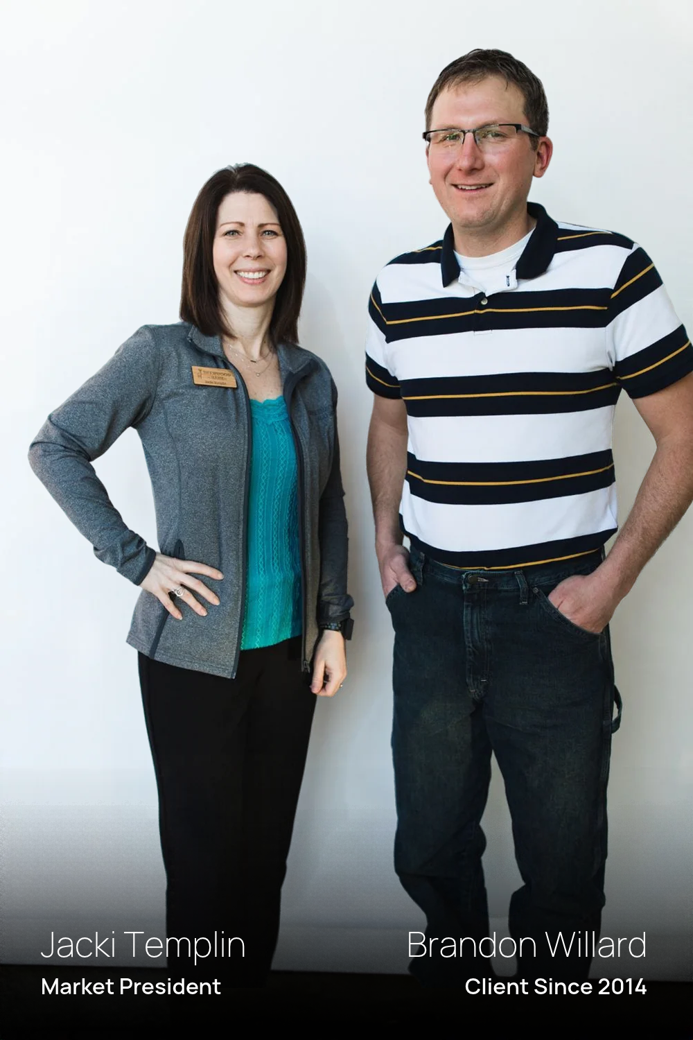 A woman with dark hair (Jacki Templin, Market President) wearing a grey zip-up jacket, teal top, and black pants stands alongside a smiling man in glasses (Brandon Willard, Client Since 2014)